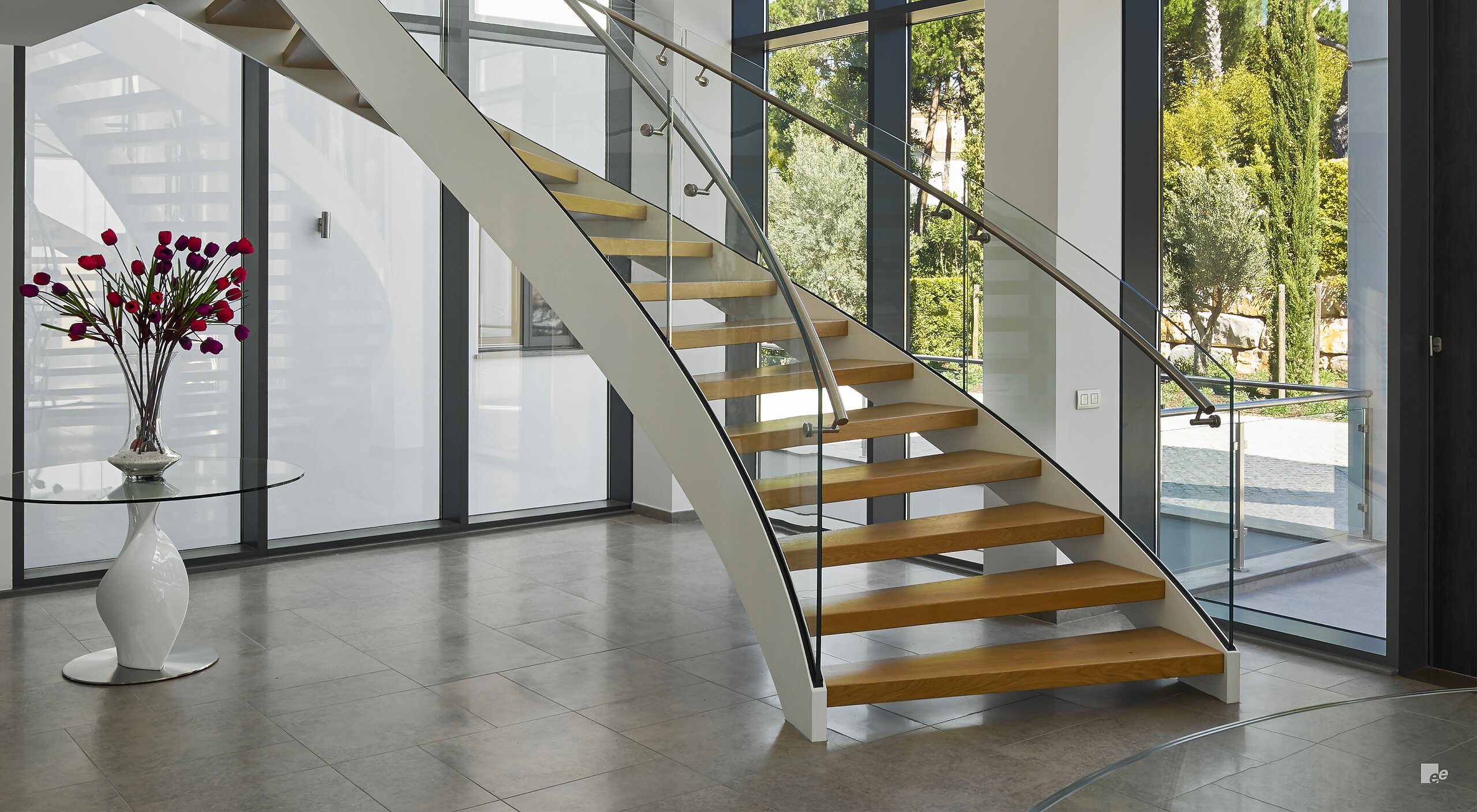 wood curved stair with metal stringer and glass railing